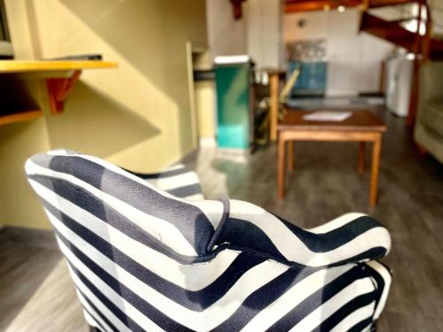 a black and white striped chair in a living room at Theven Plages in Santec