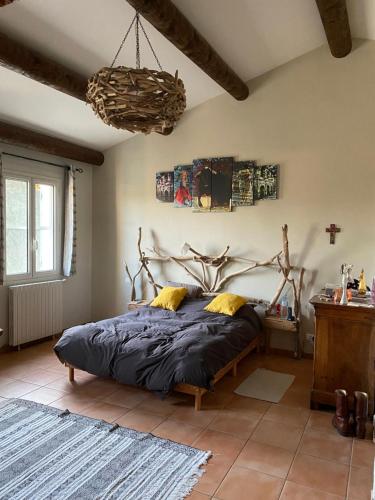 une chambre avec un lit avec une grande tête de lit en bois dans l'établissement Mas du petit Tamaris, à Arles