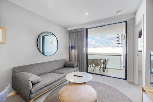 a living room with a couch and a mirror at Charming Hamilton Retreat in Brisbane