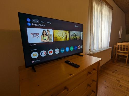 TV de pantalla plana en la parte superior de una cómoda de madera en Makovna - Apartmán Západ, en Tři Sekery