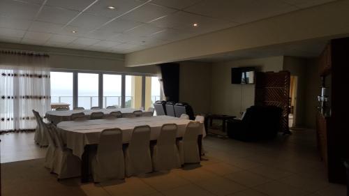a conference room with a large table and chairs at The Homestead Margate - South Africa in Margate