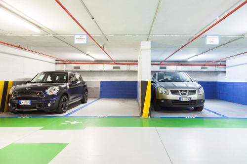 two cars are parked in a parking garage at Doria Grand Hotel in Milan