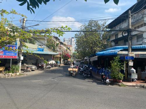 a city street with a blue bus parked next to a building at Russian Market Bakery and Guesthouse in Phnom Penh