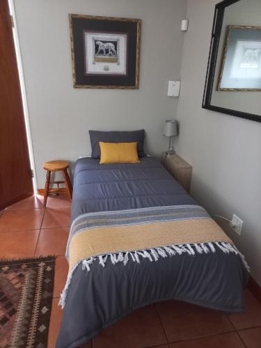 a bedroom with a bed with a blue comforter at Webbs Self catering Cottage in Vryheid