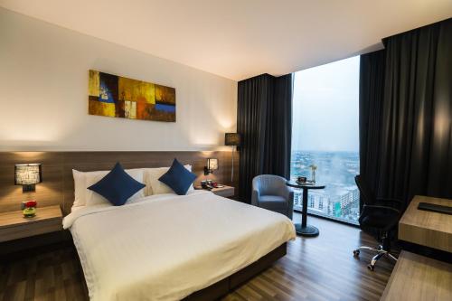 a hotel room with a bed and a large window at Best Western Plus Wanda Grand Hotel in Nonthaburi