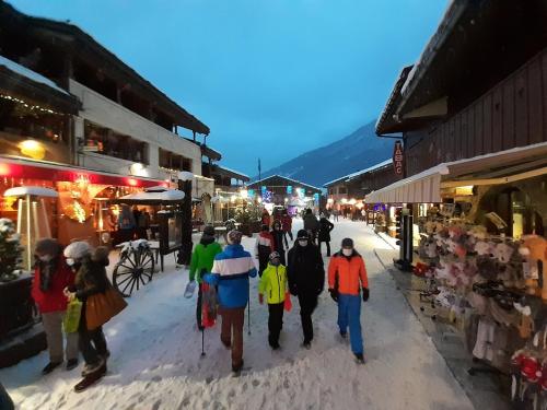 un groupe de personnes marchant dans une rue dans l'établissement Valmorel appartement, à Valmorel