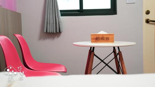 a table with pink chairs and a box on it at Yogurt Homestay in Taitung City