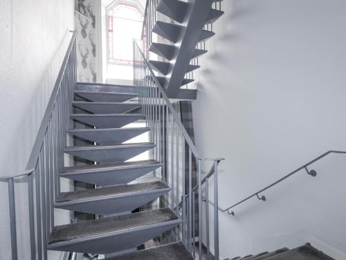 a metal spiral staircase in a room with a window at Glenspey in Kingussie
