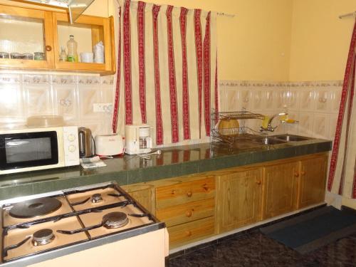 a kitchen with a stove top and a microwave at Son House Studio in Flic-en-Flac