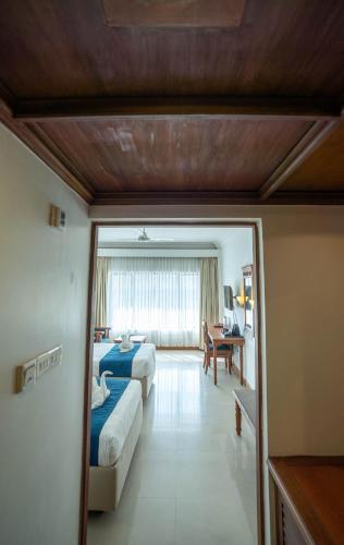 a hotel room with two beds and a desk at Casino Hotels Ltd in Trichūr