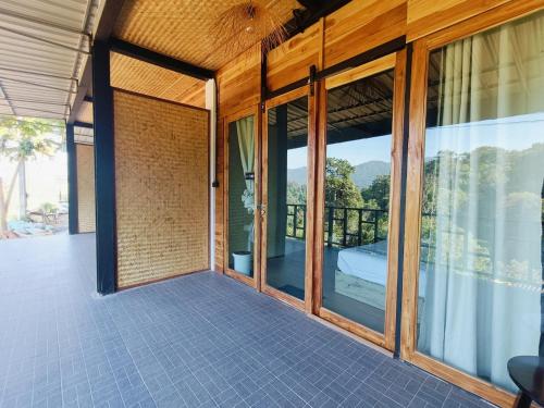 an external view of a house with large windows at Motho Homestay โมโทโฮมสเตย์ in Chom Thong