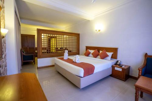 a hotel room with a bed and a desk and a table at Casino Hotels Ltd in Trichūr