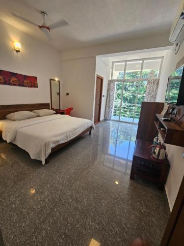 DharmastalaBougainvillea Residency的一间带床和大窗户的卧室
