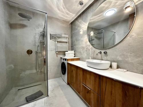 Un baño con lavabo y ducha con espejo. en Apartamenty Karin Wladyslawowo, en Władysławowo