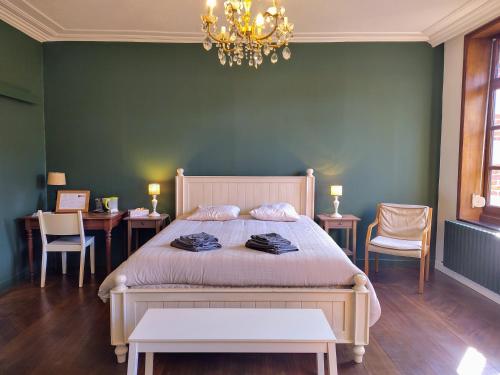 a bedroom with a bed with a green wall at Aubépine in Sains-du-Nord