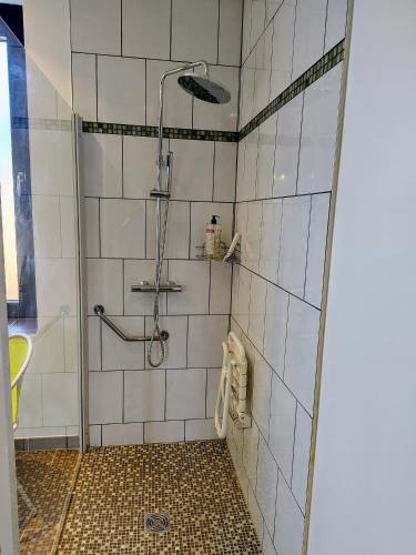 a bathroom with a shower with white tiles at Aubépine in Sains-du-Nord