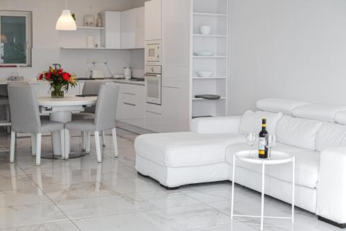 a white living room with a white couch and a table at A52 - Apartment with Sea and Country Views in Mellieħa