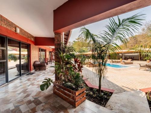 an indoor courtyard with plants and a swimming pool at Bishop House in Victoria Falls
