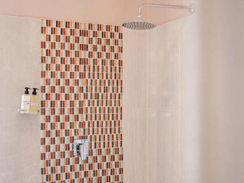 a bathroom with a shower with a tiled wall at Bishop House in Victoria Falls