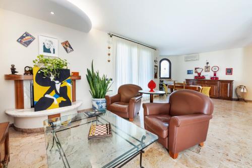 a living room with leather chairs and a glass table at Le Rose - Suites e Breakfast a 5 min dal mare e Misano World Circuit in Misano Adriatico