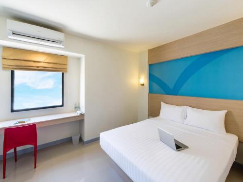 a bedroom with a bed and a desk with a laptop at HOP INN Krabi Building B in Krabi town