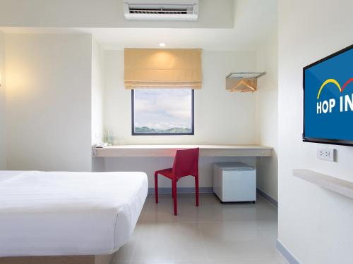 a room with a bed and a desk and a tv at HOP INN Krabi Building B in Krabi town