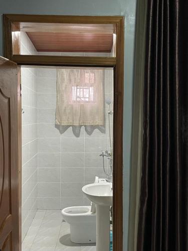 a bathroom with a toilet and a sink at Ritha Motel Apartment in Kigali