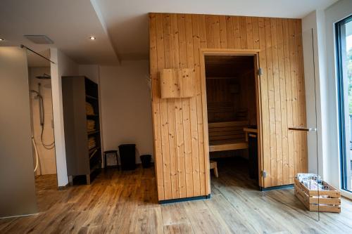 a room with a wooden wall with a closet at Hotel Garni Isarlodge Wiesenhof in Scharnitz