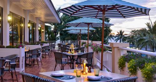 a restaurant with tables and umbrellas on a balcony at Sofitel Krabi Phokeethra Golf and Spa Resort in Klong Muang Beach