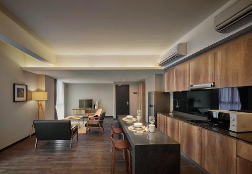 a kitchen and living room with a table and chairs at Tropics Eight Suites in George Town