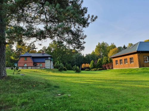 a barn and a house in a field with a tree at Lodja Jahimaja in Parnumaa