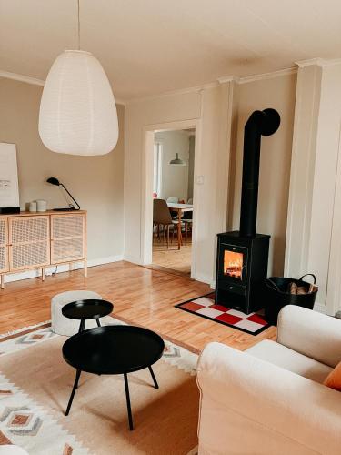 a living room with a fireplace and a couch at Charming house with wood stove near lake in Virserum