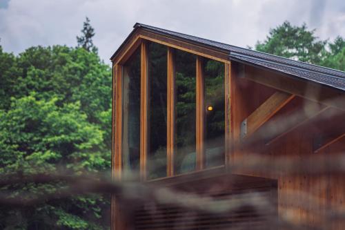 a house with glass windows on the side of it at Earthboat Minakami Hodaigi in Minakami