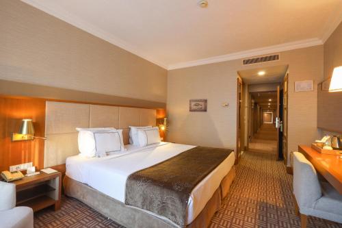 a hotel room with a large bed and a chair at Tugcan Hotel in Gaziantep