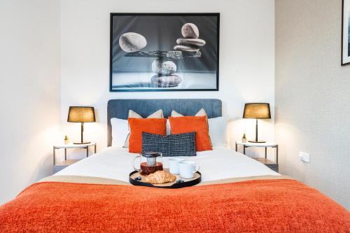 a bed with a tray of food on it at TheCountingSheep - Heathrow in 15 mins - Glass Balcony - Dedicated Workspace in Hounslow