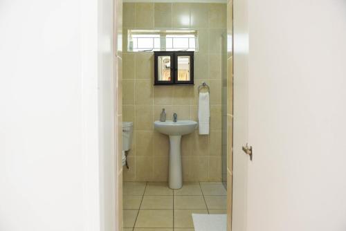 a bathroom with a sink and a toilet at Webbs Self catering Cottage in Vryheid