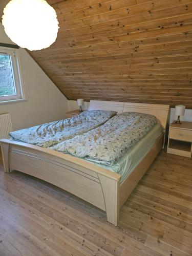 a bed in a bedroom with a wooden ceiling at Rolige omgivelser på landet i Dorf in Dronninglund