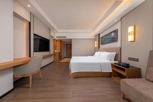 a hotel room with a bed and a tv at 汉诺酒店-Canton Fair Free Shuttle Bus in Guangzhou