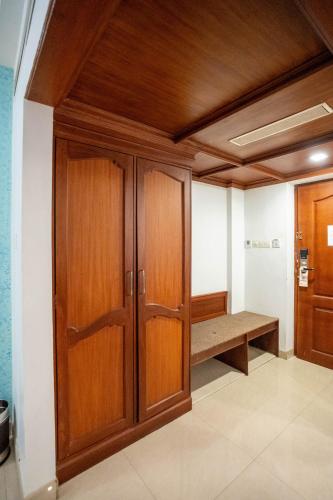 a room with wooden cabinets and a bench at Casino Hotels Ltd in Trichūr