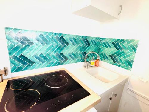 Il comprend une cuisine équipée d'une cuisinière. four supérieur à côté d'un évier dans l'établissement Superbes Studios av Versailles a Paris 16, à Paris