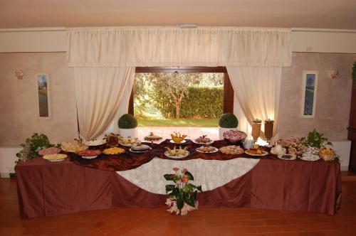 a table with food on it in a room with a window at Hotel Borgo degli Olivi in Riotorto