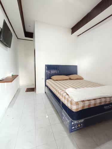 a bedroom with a bed in a room at Agung Homestay And Foodie in Kalawas