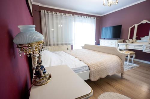 a bedroom with a bed and a table with a lamp at Chios Lake Apartament in Cluj-Napoca