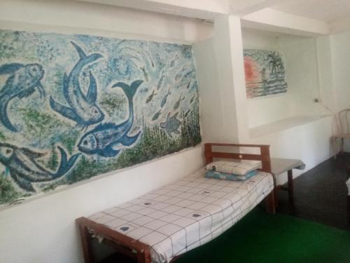a small bed in a room with a painting on the wall at ASK Nomads in Ella