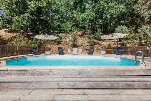 une piscine avec chaises et parasols dans l'établissement Domaine du Roc Gîtes 34 personnes, à Campagnac-lès-Quercy