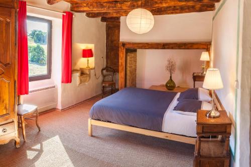 a bedroom with a large bed and a window at Domaine du Roc Gîtes 34 personnes in Campagnac-lès-Quercy