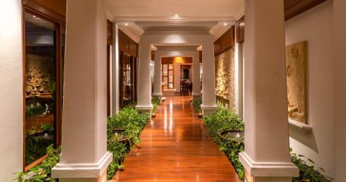 a hallway of a building with columns and plants at Sofitel Krabi Phokeethra Golf and Spa Resort in Klong Muang Beach