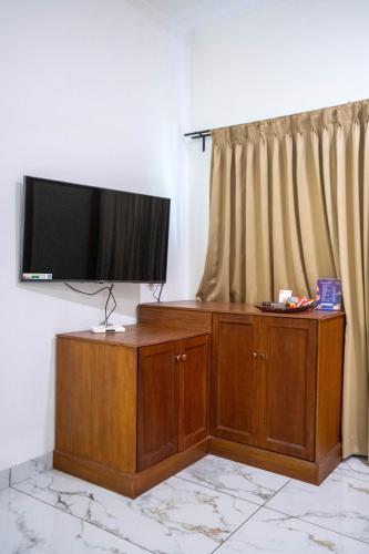 a flat screen tv on top of a wooden cabinet at Casino Hotels Ltd in Trichūr