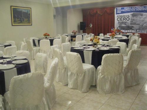 a room full of tables and chairs with white chairs and tablesearcher at Casona Plaza Hotel Puno in Puno
