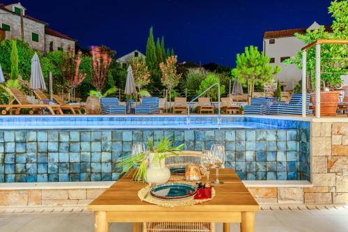 a table in front of a swimming pool at Hotel Brattia, Adults Only, Heated Pool, A la Carte Breakfast, Postira, Brač Island in Postira